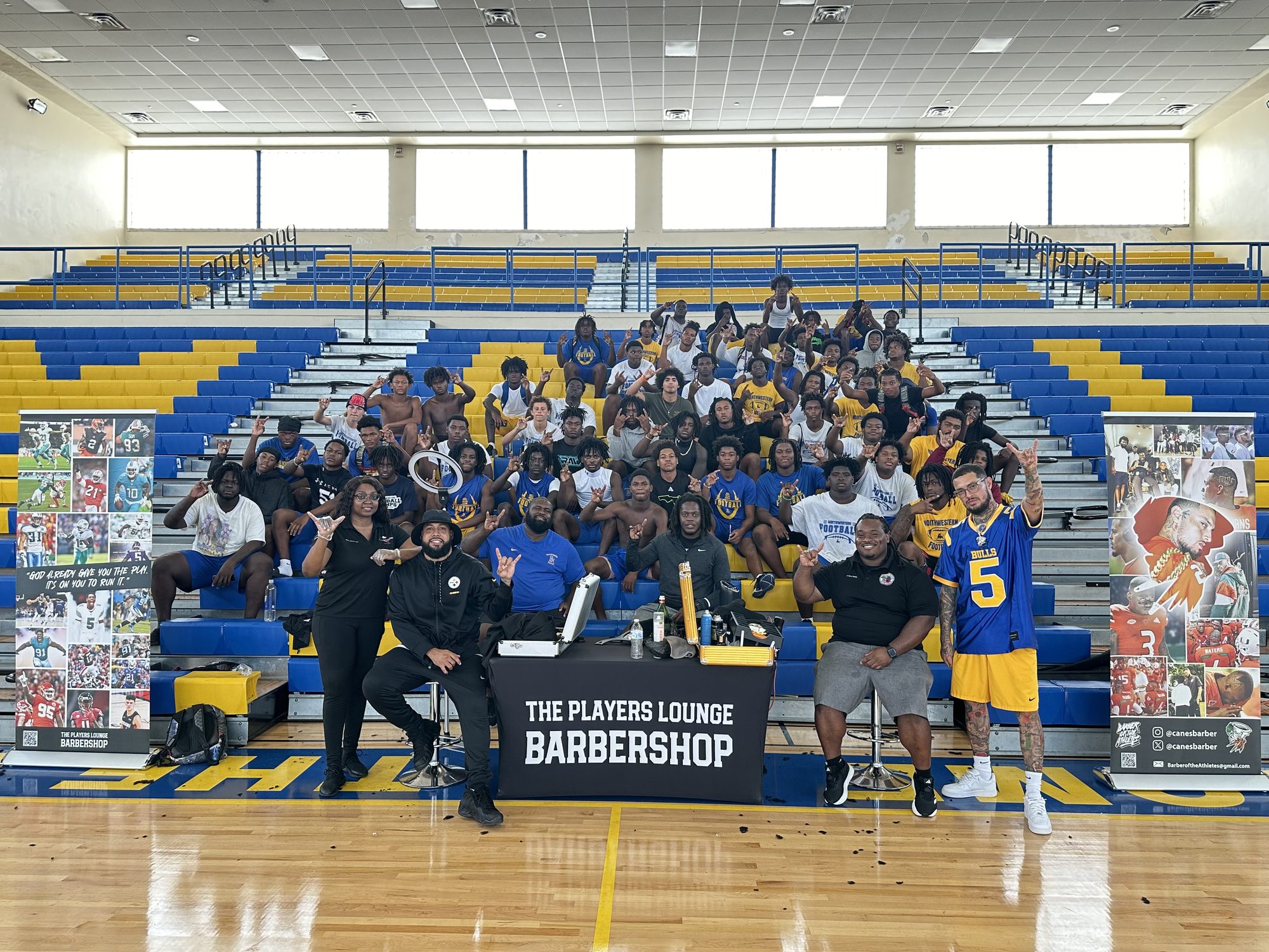 Steven and his team of barbers with a high school football team in the gym